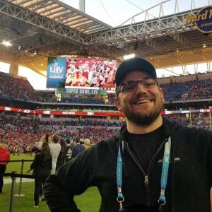 Lucas Ingram in front of a scoreboard at the Super Bowl.