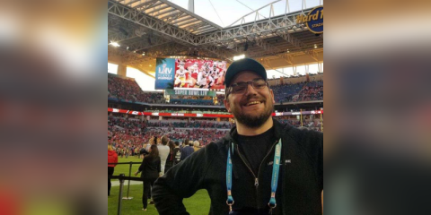 Lucas Ingram at the Super Bowl in front of the scoreboard.