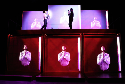Purple and red lighted square blocks with musicians standing on them performing.