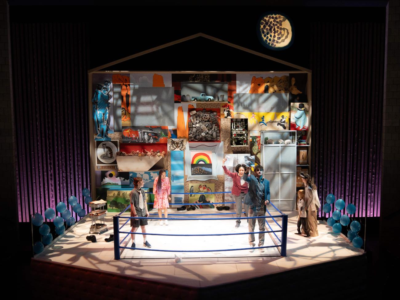 Ryan, Robin, Ash, and Peter stand together in the boxing ring as Jeenu and Wolf watch from the sidelines.