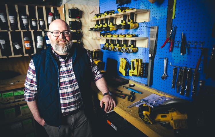 Trevor Flocco standing at his work station with tools in the background