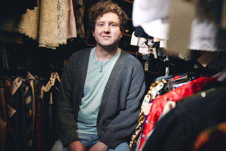 Tyler Felton sitting in a costume room.