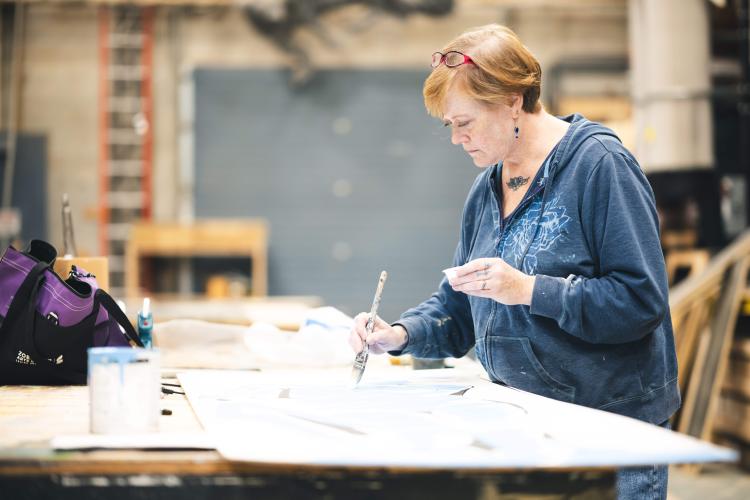 Carrie Ballenger painting in a studio.