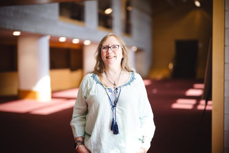 Mary Anne Swords-Greene wearing a white blouse smiling for her portrait in Zoellner's foyer.