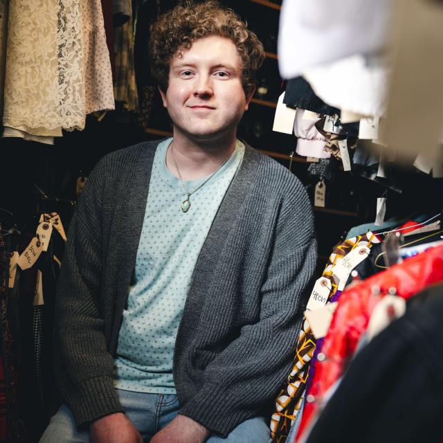 Tyler Felton sitting in a costume room.