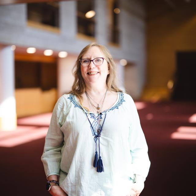 Mary Anne Swords-Greene wearing a white blouse smiling for her portrait in Zoellner's foyer.
