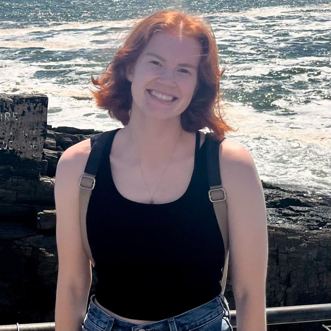 Laurel Marx wearing a backpack standing by the ocean.