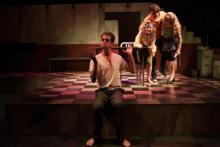 Lehigh University Theatre - The Pillowman, man sitting on edge of stage with no shoes