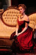 Lehigh University Theatre - The Little Foxes, woman in red dress sitting on couch